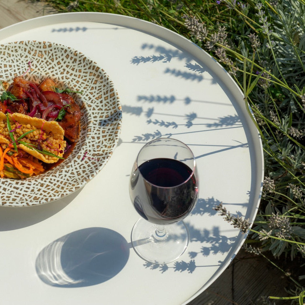 Glas georgischer Naturwein neben georgischem Essen – handwerklich hergestellt ohne Zuckerzusatz